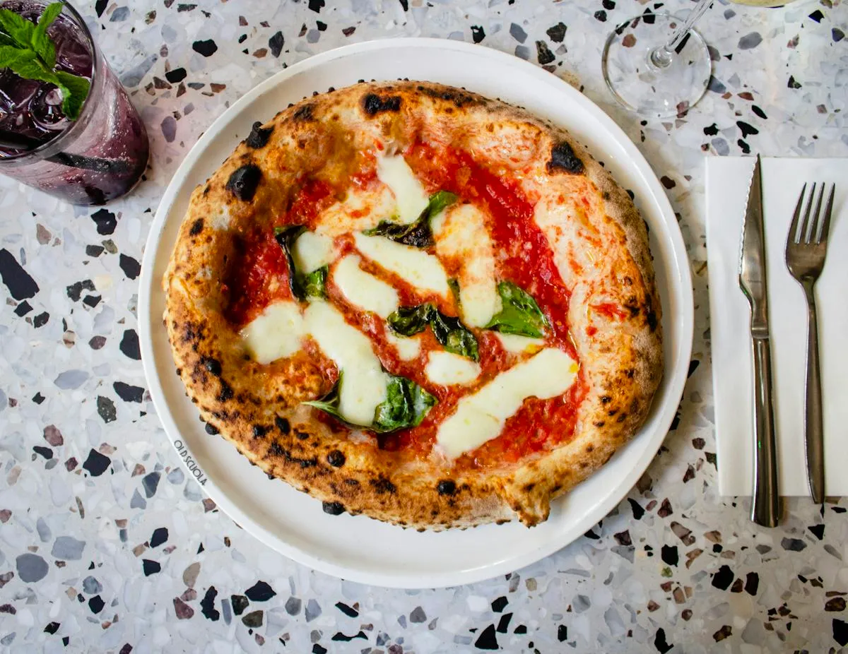 Fresh pizza with melted cheese and herbs